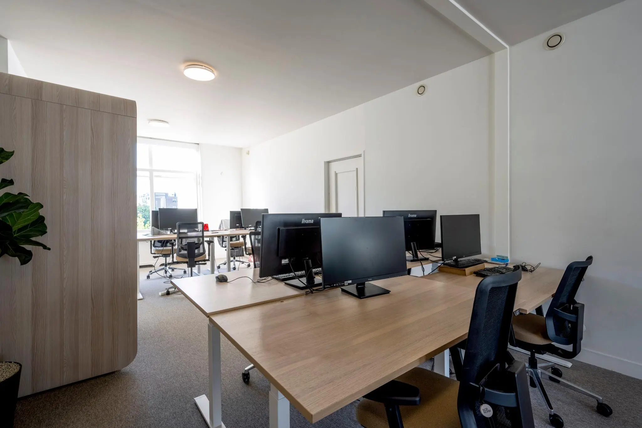 Modern kantoor met meerdere werkplekken, bureaustoelen en computerschermen aan de Prof. Tulpstraat.